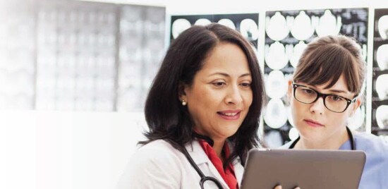 Two medical professionals looking at a tablet.
