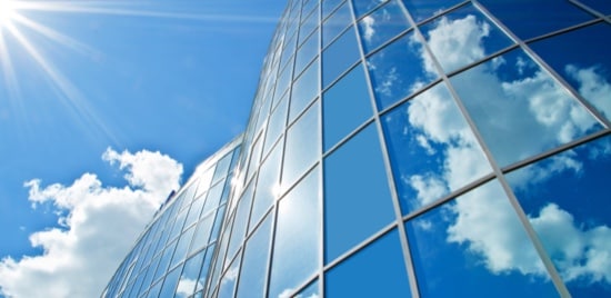 The exterior of a building, made up of windows reflecting the sky.
