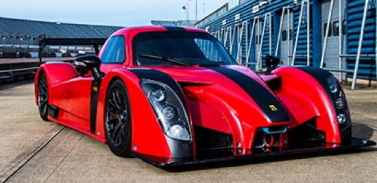 Une voiture rouge et noir stationnée sur une piste de course.
