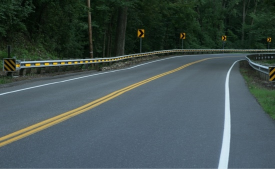 A bend in a rural road during the day.
