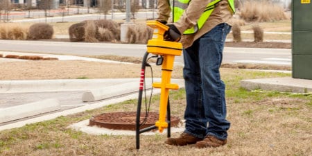 Un travailleur utilise un équipement de localisation et de marquage 3M pour détecter des actifs souterrains.
