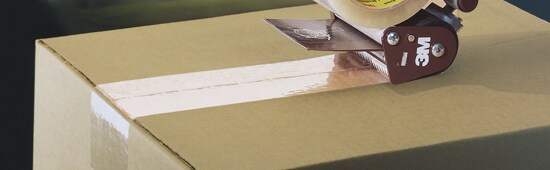 Une boîte que l’on scelle avec du ruban.
