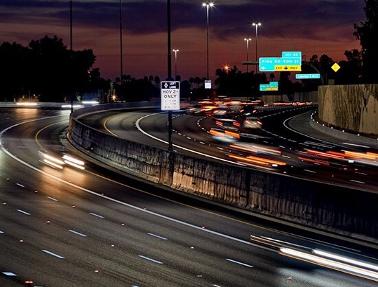Blurry cars driving on a highway at night.
