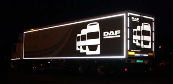 A trailer with white reflective vehicle graphics.
