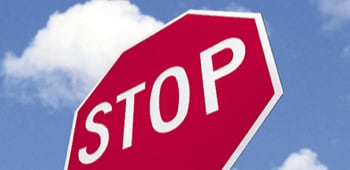 A stop sign in front of a blue sky.
