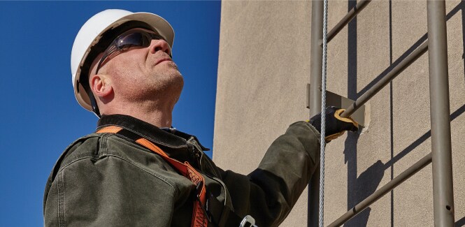 A worker wearing 3M fall protection equipment.
