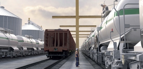 Un travailleur sur le toit d’un wagon dans un parc ferroviaire, attaché à un système de rail rigide.
