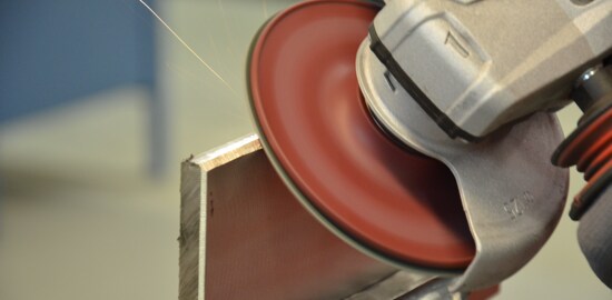 A 3M™ Cubitron™ II Fibre Disc 982C grinding a piece of metal.
