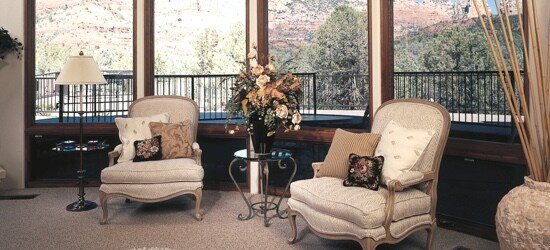 Un salon convivial muni de fenêtres avec vue sur une cour paysagée.
