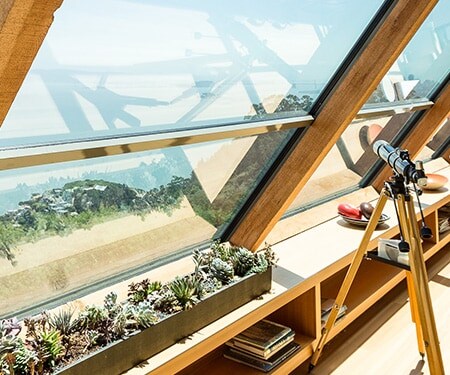 Un intérieur baigné de lumière, avec de vastes baies vitrées offrant une vue sur la plage.
