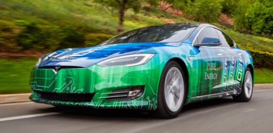 A car wrapped in 3M™ Envision™ Wrap Film 48mC, driving down a road.
