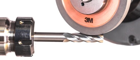 A drill bit touching a 3M™ Diamond Grinding Wheel X-Series.

