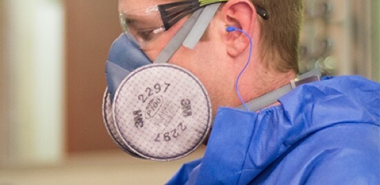 Un travailleur portant des lunettes de sécurité et un respirateur réutilisable à demi-masque.
