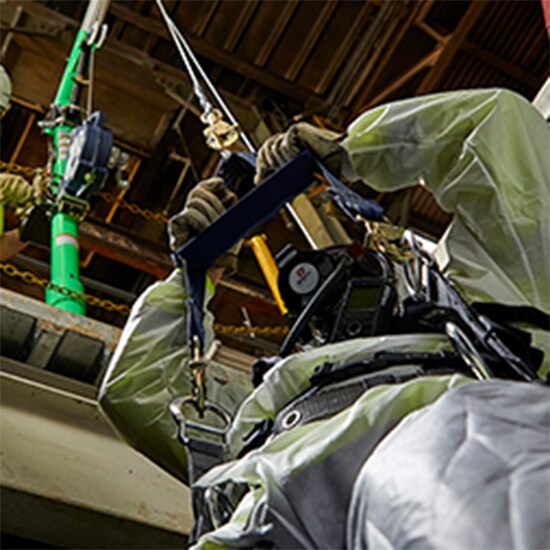 Looking up at worker entering confined space using a 3M™ Fall Protection system.
