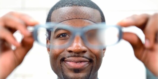 Worker holding a pair of protective eyewear

