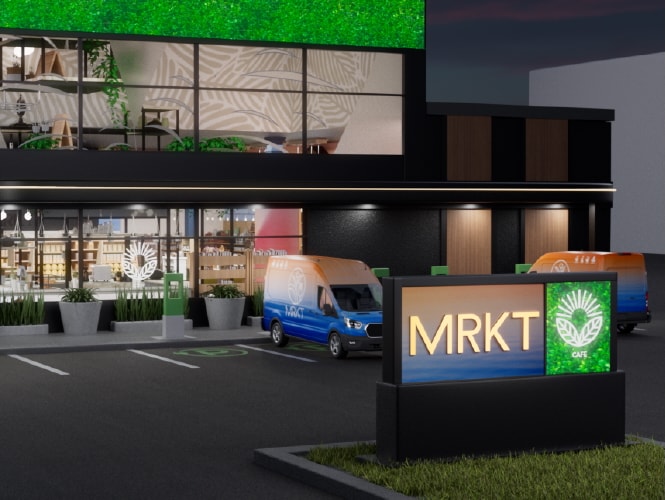 Une devanture avec des enseignes lumineuses et un stationnement, présentant un mur vert et des camionnettes de livraison.
