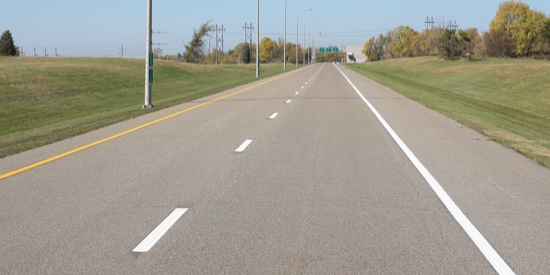 A rural road with liquid pavement markings.
