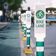 Une rangée de panneaux indiquant une bande cyclable protégée.