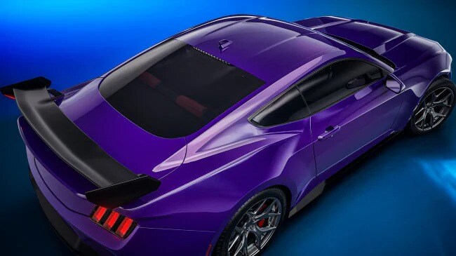 Close-up of the spoiler and hood on a purple sports car.
