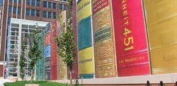 Graphic films covering the side of a building with vertical strips of different designs.

