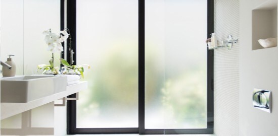 Deux grandes fenêtres en verre dépoli dans une salle de bains.
