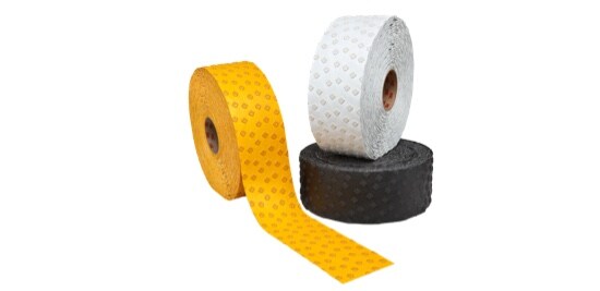 Three rolls of tape, one white, one yellow and one black.
