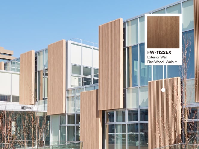 Exterior of building with glass and wood façade featuring product callout of Walnut DINOC Exterior film.
