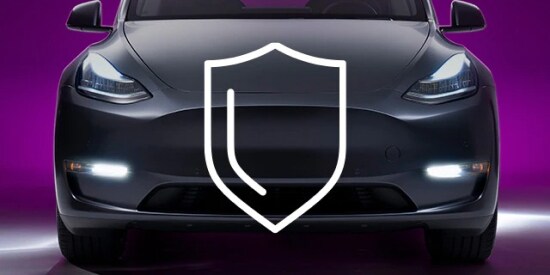 Icon of shield overlayed on the front bumper of an matte gray EV car with protective film.

