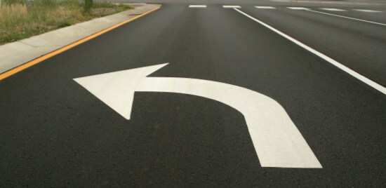 Une grande flèche de virage à gauche sur la chaussée d’une voie de virage gauche.
