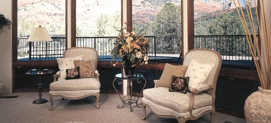 A formal living room, with a landscaped backyard visible through the windows.
