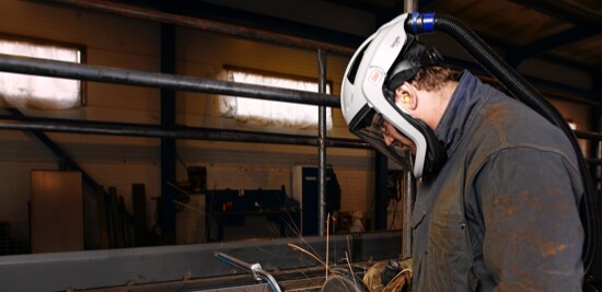 A worker wearing a powered air purifying respirator.

