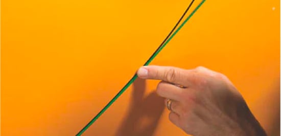 Une main qui applique le Ruban avec fil de carbone pour lignes de précision 3MMC à la ligne entre deux panneaux d’une voiture.
