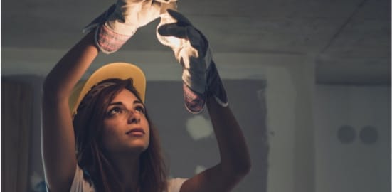 Un électricien installe une ampoule.
