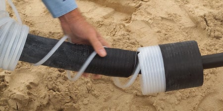 Un ouvrier déroule une épissure rétractable à froid 3M.
