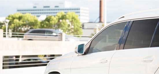A car with tinted windows in a parking lot.
