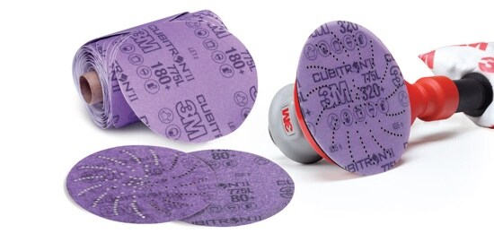 Deux Disques en pellicule 775L Cubitron(MC) II 3M(MC) violets, un troisième sur une ponceuse et un Rouleau de disques en pellicule 775L Stikit(MC) Cubitron(MC) II 3M(MC).
