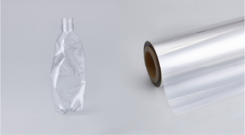 Bouteille en plastique aux côtés d’un rouleau de pellicule architecturale DI-NOC.
