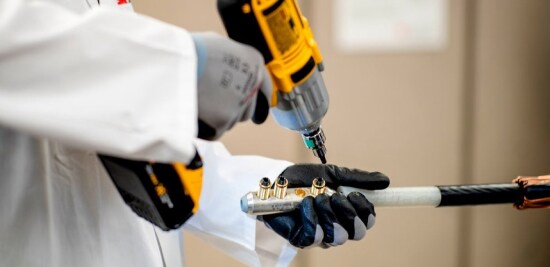 Ouvrier de services publics d’électricité installant un connecteur à boulon de cisaillement mécanique.
