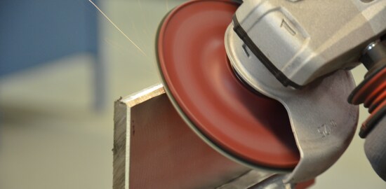 A 3M™ Cubitron™ II Fibre Disc 982C grinding a piece of metal.
