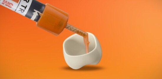 An orange syringe of 3M™ RelyX™ Universal Resin Cement applying cement to a crown.
